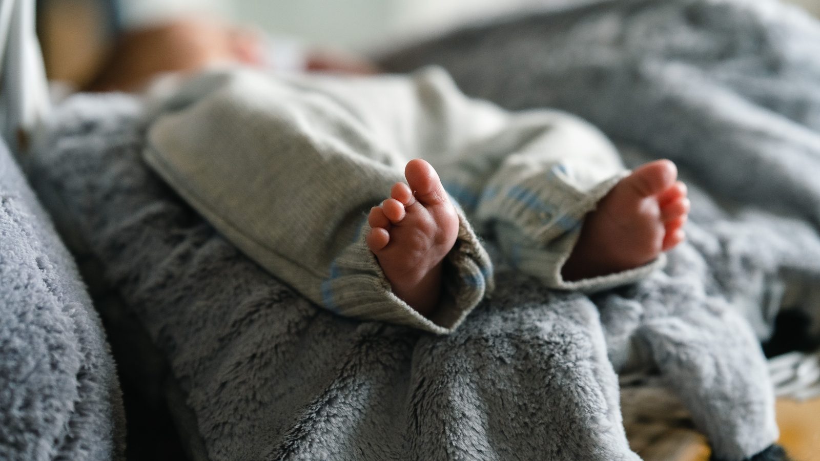 Close-up of baby feet resting on a soft blanket