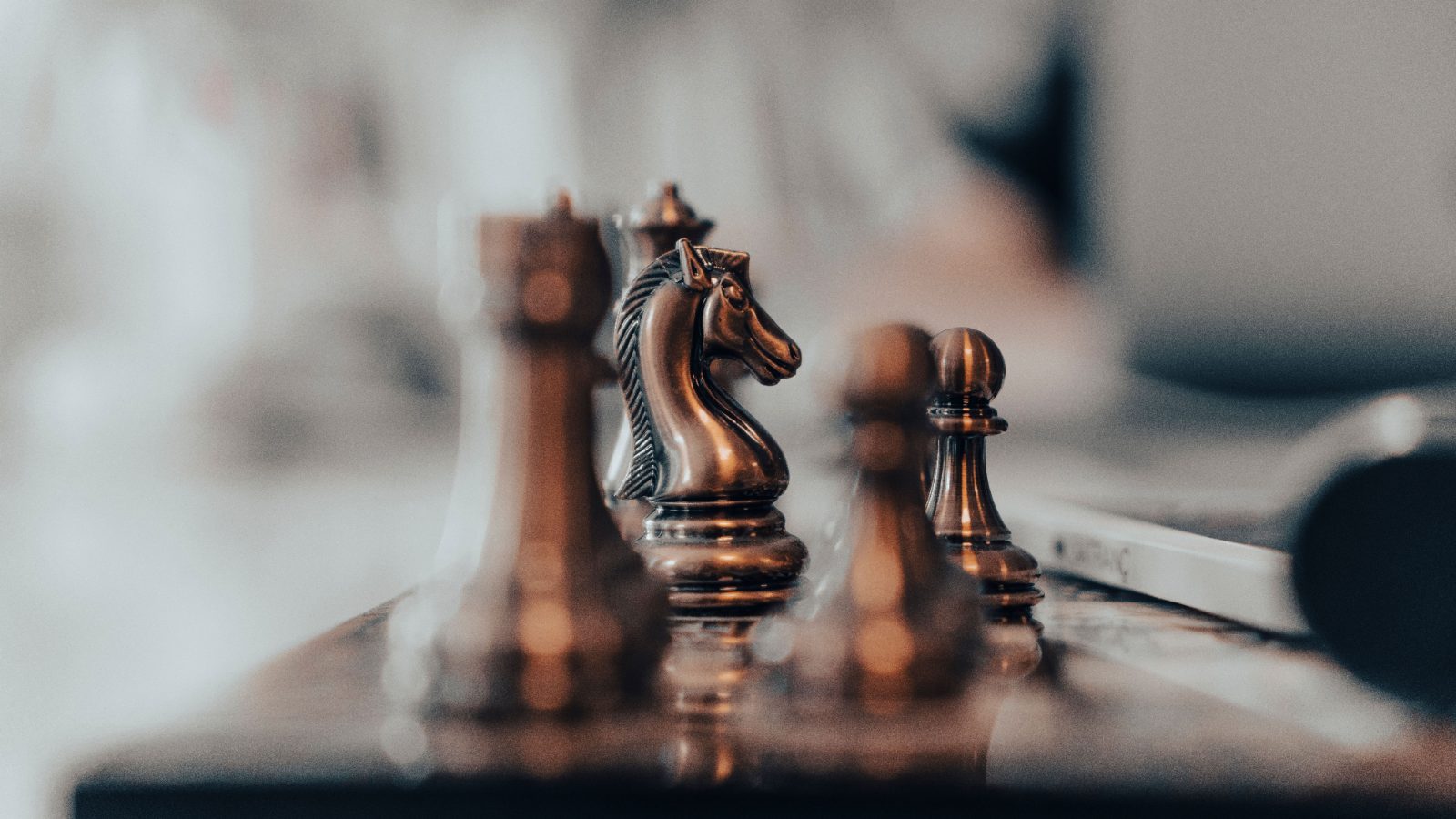 Close-up of wooden chess pieces on a board in warm tones