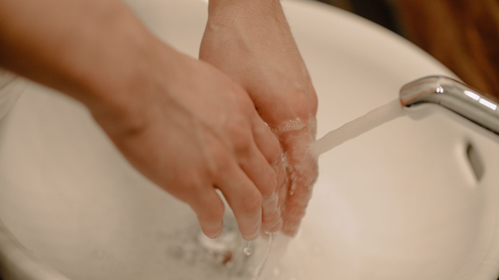 Hands being washed under running water, representing hygiene and clean water